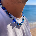 Collana uomo Lipari in vetro di Murano blu e azzurra indossata in spiaggia - Dandy Street