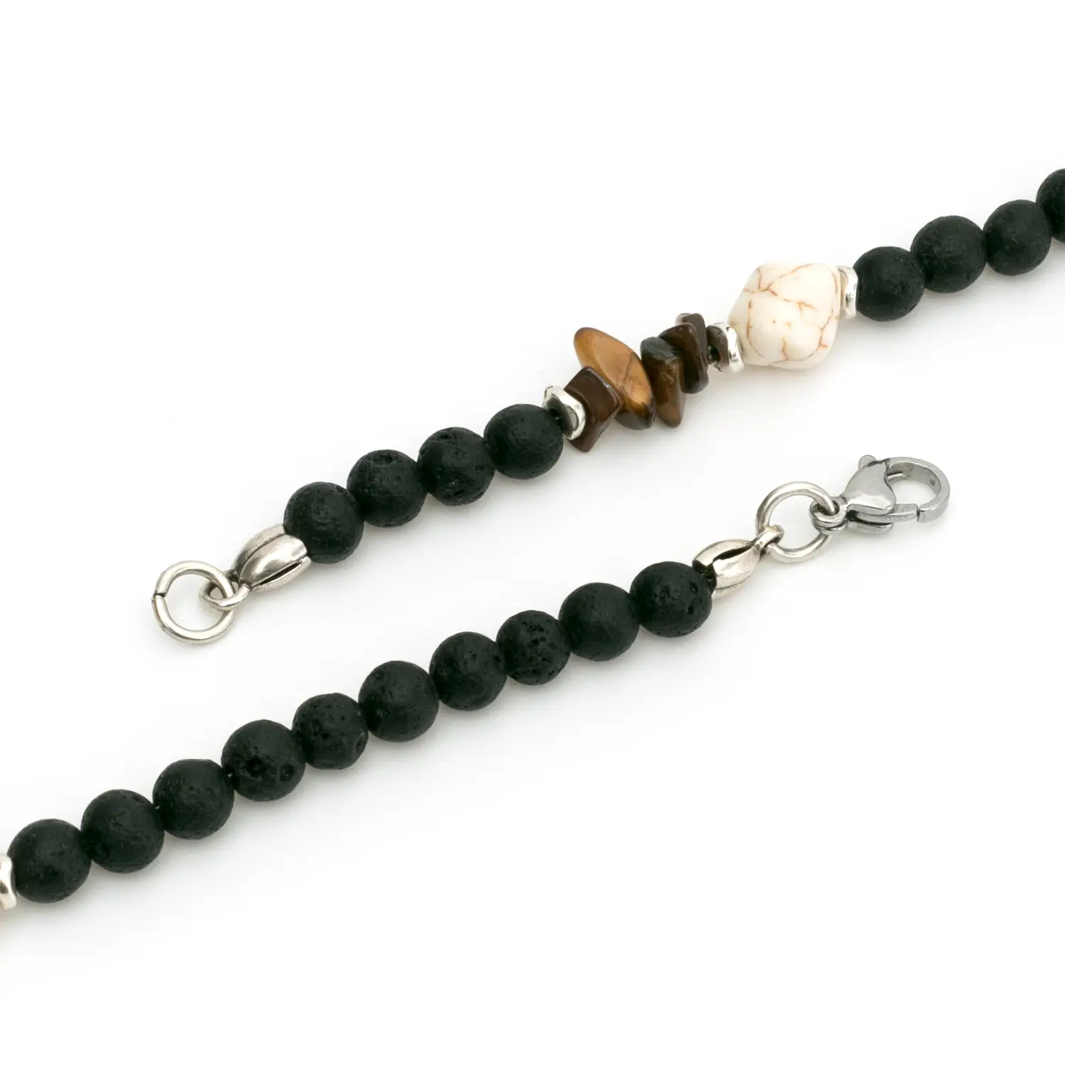 Thales è una collana da uomo realizzata a mano in Italia con pietre naturali di qualità, che donano un tocco di stile e personalità al tuo look, un accessorio che incanta per la sua moderna raffinatezza. Intrecciata con pietra lavica dall'aspetto poroso che contrasta con l'aulite bianca, questa creazione esclusiva, grazie anche all'occhio di tigre, evoca un senso di avventura e mistero.<br /> Queste pietre hanno anche dei significati simbolici: la pietra lavica rappresenta la forza e la trasformazione, mentre l’occhio di tigre stimola la fiducia e la protezione.<br /> Questa collana si abbina con naturalezza a outfit casual e sportivi e anche con colori caldi e neutri. È perfetta per le vacanze estive o per regalare un tocco casual al tuo look quotidiano in tutte le stagioni. ndossa Thales e lasciati trasportare in un viaggio di stile e libertà, dove ogni dettaglio racconta una storia senza tempo. <ul class="testo-prodotti"> <li class="spaziatura"><strong>Materiali</strong>: Minuterie e chiusura placcate argento 5 micron, ciuffo di bandana in cotone</li> <li class="spaziatura"><strong>Pietre</strong>: Pietra lavica con taglio a perla, aulite bianca a sasso e chips di occhio di tigre marrone</li> <li class="spaziatura"><strong>Taglia Unica</strong>: La lunghezza totale della collana è di 70cm</li> <li class="spaziatura"><strong>Chiusura</strong>: Con moschettone</li> <li class="spaziatura"><strong>Confezione</strong>: La collana è venduta all'interno di un'elegante scatolina con logo Dandy Street. Perfetta anche come regalo!</li> </ul> Thales è una collana da uomo realizzata a mano in Italia con pietre naturali di qualità, che donano un tocco di stile e personalità al tuo look, un accessorio che incanta per la sua moderna raffinatezza. Intrecciata con pietra lavica dall'aspetto poroso che contrasta con l'aulite bianca, questa creazione esclusiva, grazie anche all'occhio di tigre, evoca un senso di avventura e mistero. Queste pietre hanno anche dei significati simbolici: la pietra lavica rappresenta la forza e la trasformazione, mentre l’occhio di tigre stimola la fiducia e la protezione. Questa collana si abbina con naturalezza a outfit casual e sportivi e anche con colori caldi e neutri. È perfetta per le vacanze estive o per regalare un tocco casual al tuo look quotidiano in tutte le stagioni. ndossa Thales e lasciati trasportare in un viaggio di stile e libertà, dove ogni dettaglio racconta una storia senza tempo. Materiali: Minuterie e chiusura placcate argento 5 micron, ciuffo di bandana in cotone Pietre: Pietra lavica con taglio a perla, aulite bianca a sasso e chips di occhio di tigre marrone Taglia Unica: La lunghezza totale della collana è di 70cm Chiusura: Con moschettone Confezione: La collana è venduta all'interno di un'elegante scatolina con logo Dandy Street. Perfetta anche come regalo!